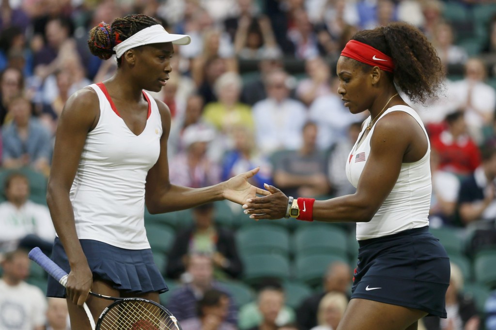 Serena Williams of the U.S. confers with her sister, Venus Williams, in the women's doubles tennis gold medal match against Czech Republic's Hlavackova and Hradecka at the London Olympic Games